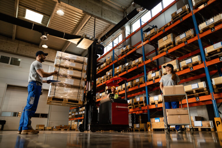 below view of group of workers cooperating in a warehouse.